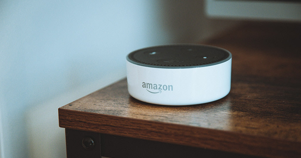 Amazon Echo Dot speaker on brown wooden table