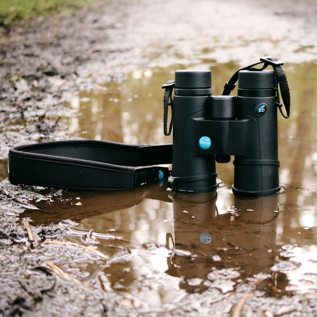Viking Kestrel binoculars sitting in muddy puddle
